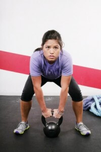 girl lifting kettlebell at gym